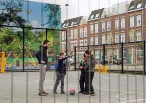 Father and kids playing in a school playground in BoTu, Rotterdam.
